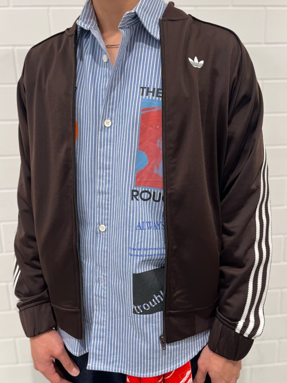 ブラウン系のジャージ、ホワイト系のスニーカーを着用したメンズの冬コーディネートの3枚目の写真