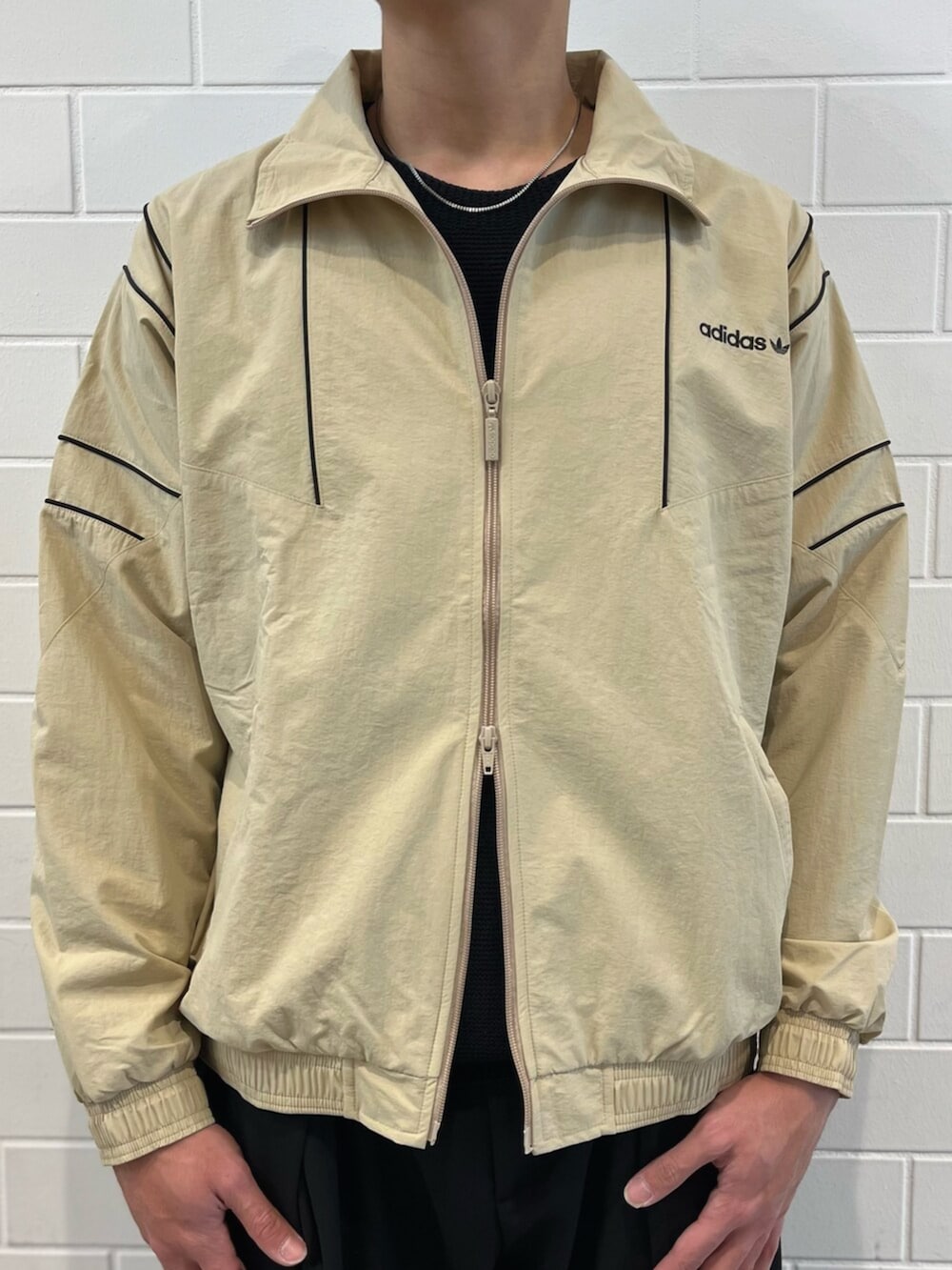 ブラウン系のスニーカー、ベージュ系のジャージを着用したメンズの春コーディネートの3枚目の写真