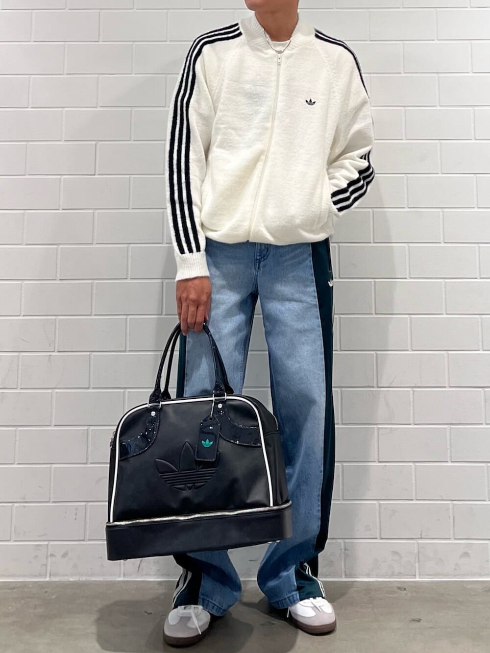 ホワイト系のジャージ、ブルー系のデニムパンツ、ブラック系のショルダーバッグを着用したメンズの秋コーディネートの2枚目の写真