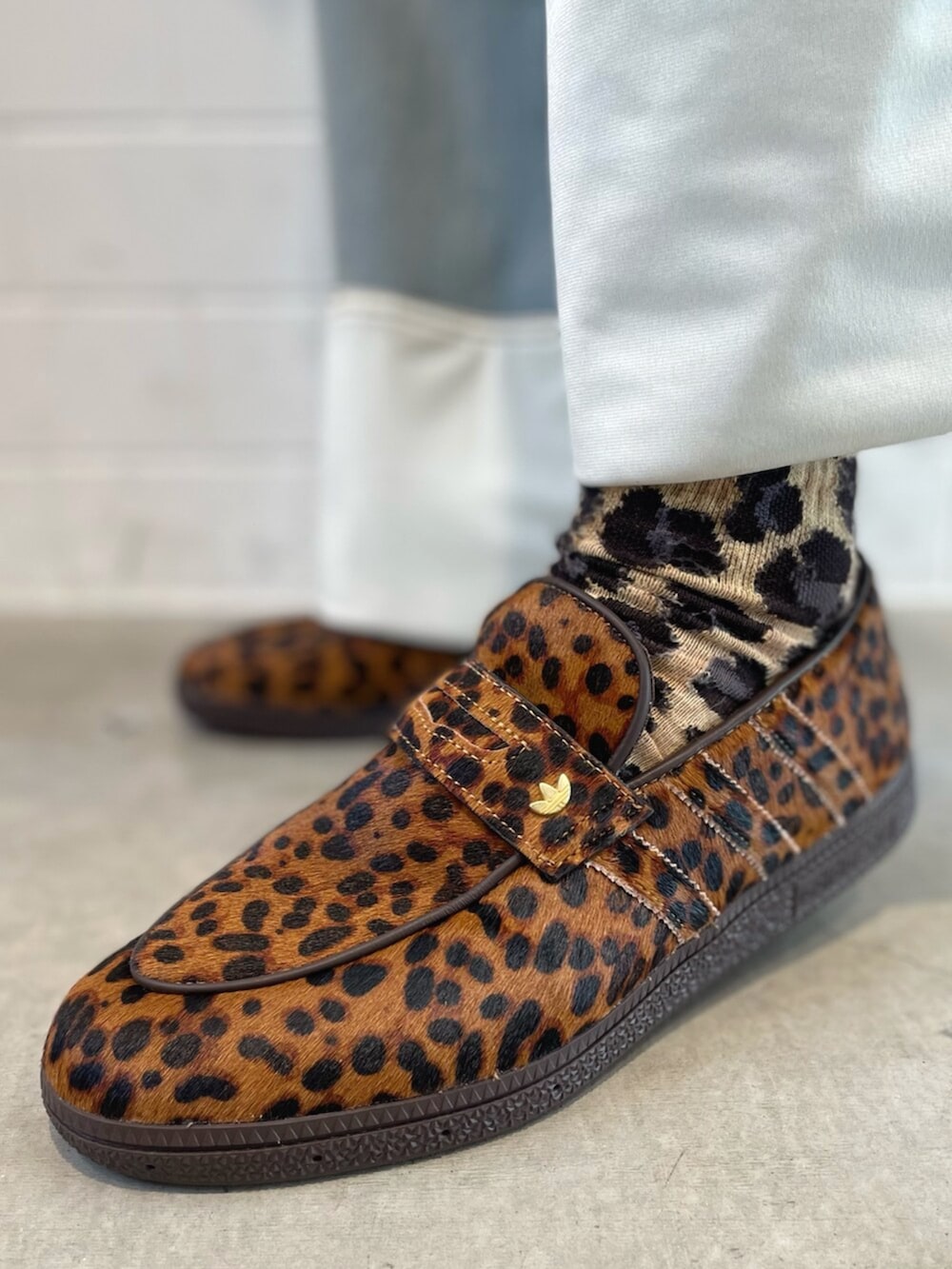 ブラウン系のジャージ、ブルー系のデニムパンツ、ブラック系のショルダーバッグを着用したメンズの春コーディネートの6枚目の写真