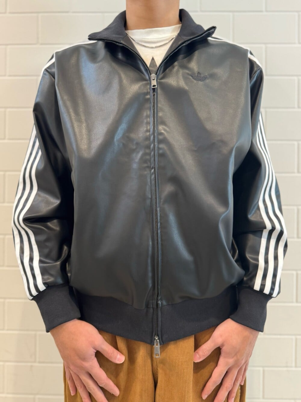 ブラウン系のその他パンツ、ブラック系のトップス、ブラック系のスニーカーを着用したメンズの冬コーディネートの4枚目の写真