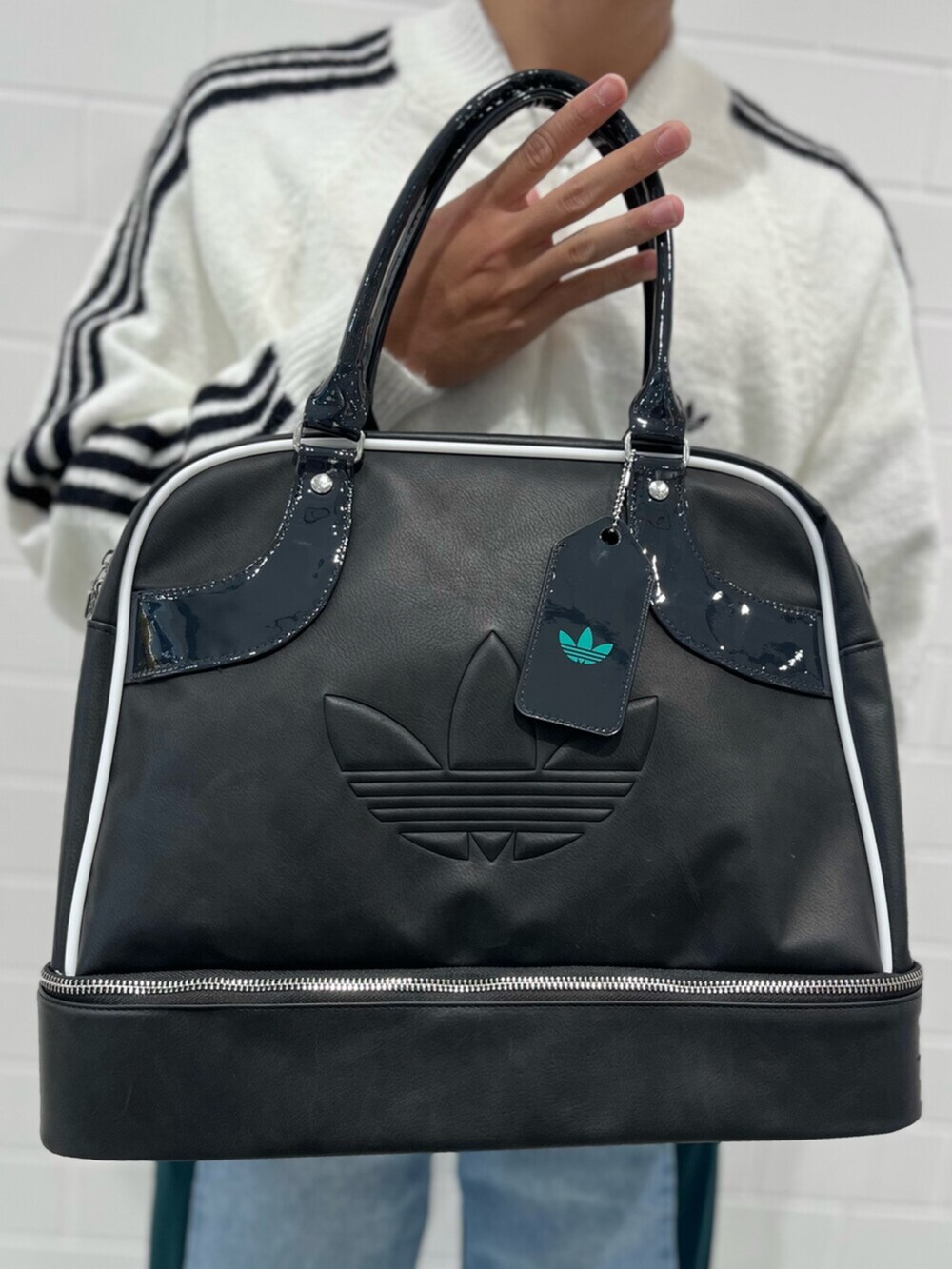 ホワイト系のジャージ、ブルー系のデニムパンツ、ブラック系のショルダーバッグを着用したメンズの秋コーディネートの4枚目の写真