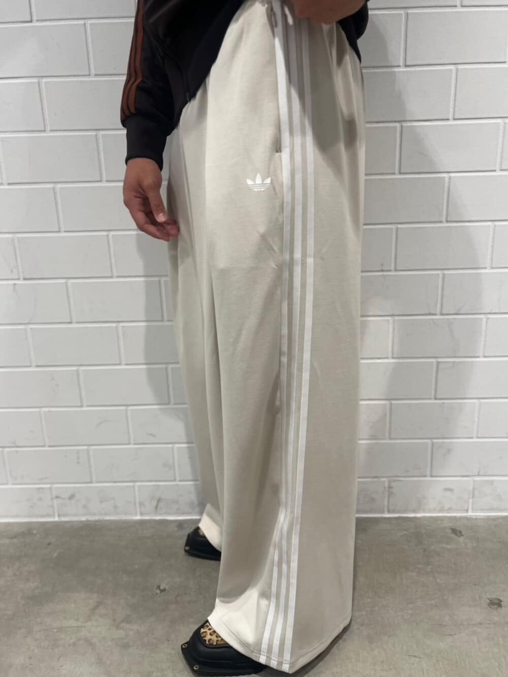 ベージュ系のスウェットパンツ、ブラウン系のジャージ、ブラック系のシューズを着用したメンズの秋コーディネートの5枚目の写真