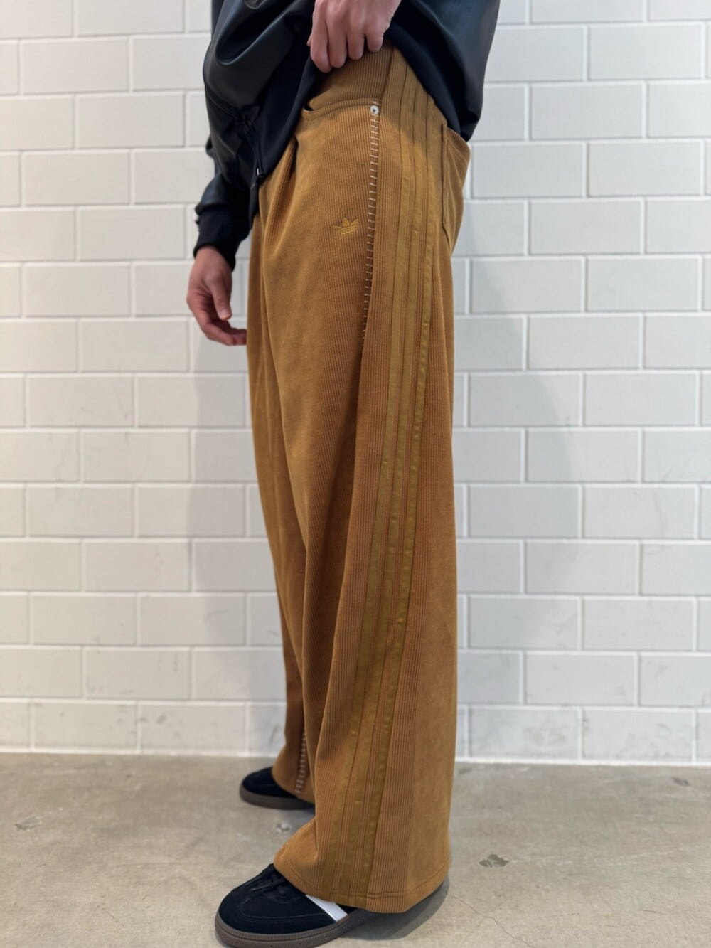 ブラウン系のその他パンツ、ブラック系のトップス、ブラック系のスニーカーを着用したメンズの冬コーディネートの5枚目の写真