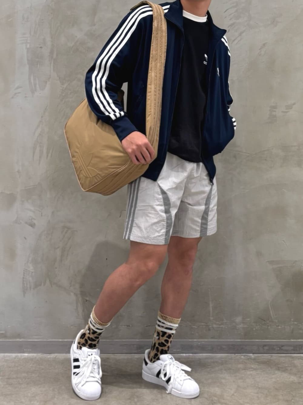 ホワイト系のスニーカー、グレー系のその他パンツ、ブラウン系のショルダーバッグを着用したメンズの夏コーディネートの2枚目の写真