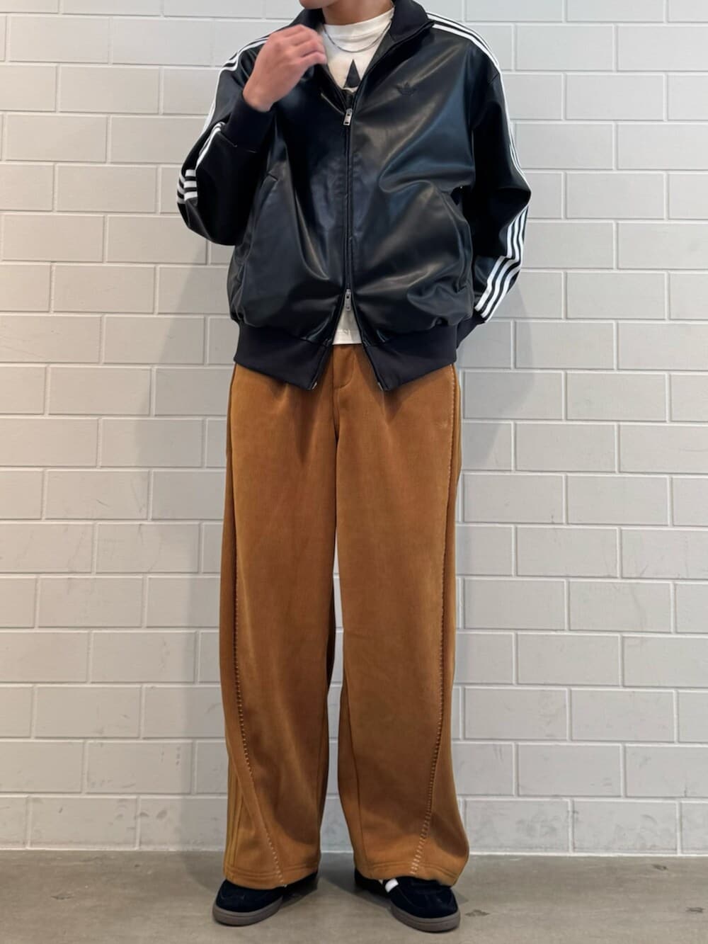 ブラウン系のその他パンツ、ブラック系のトップス、ブラック系のスニーカーを着用したメンズの冬コーディネートの2枚目の写真