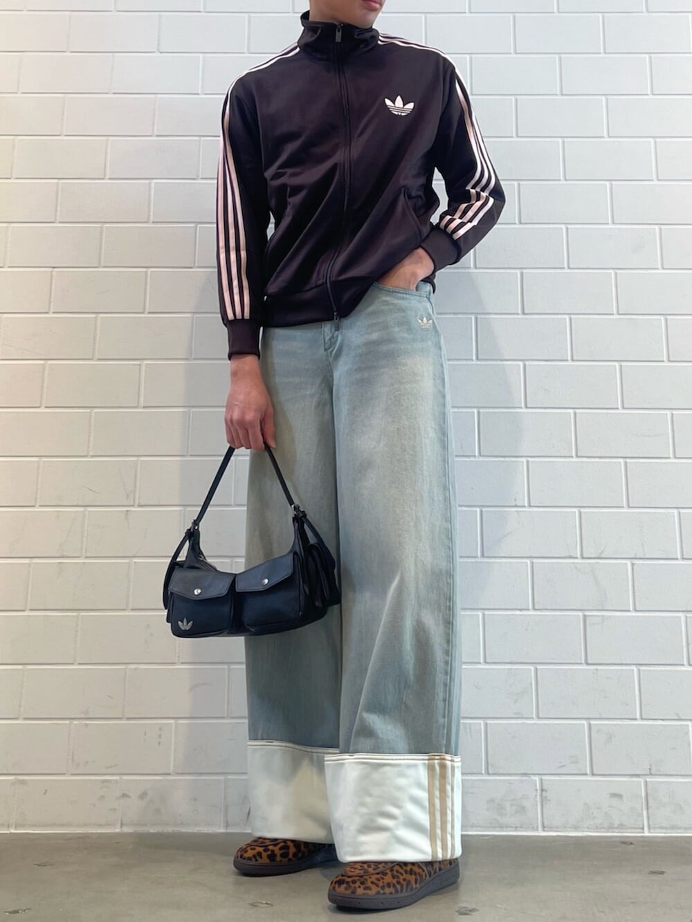 ブラウン系のジャージ、ブルー系のデニムパンツ、ブラック系のショルダーバッグを着用したメンズの春コーディネートの2枚目の写真