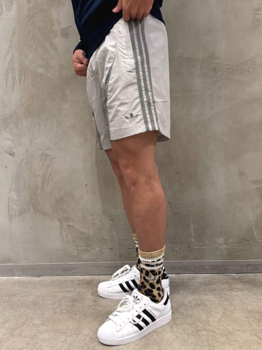 ホワイト系のスニーカー、グレー系のその他パンツ、ブラウン系のショルダーバッグを着用したメンズの夏コーディネートの5枚目の写真