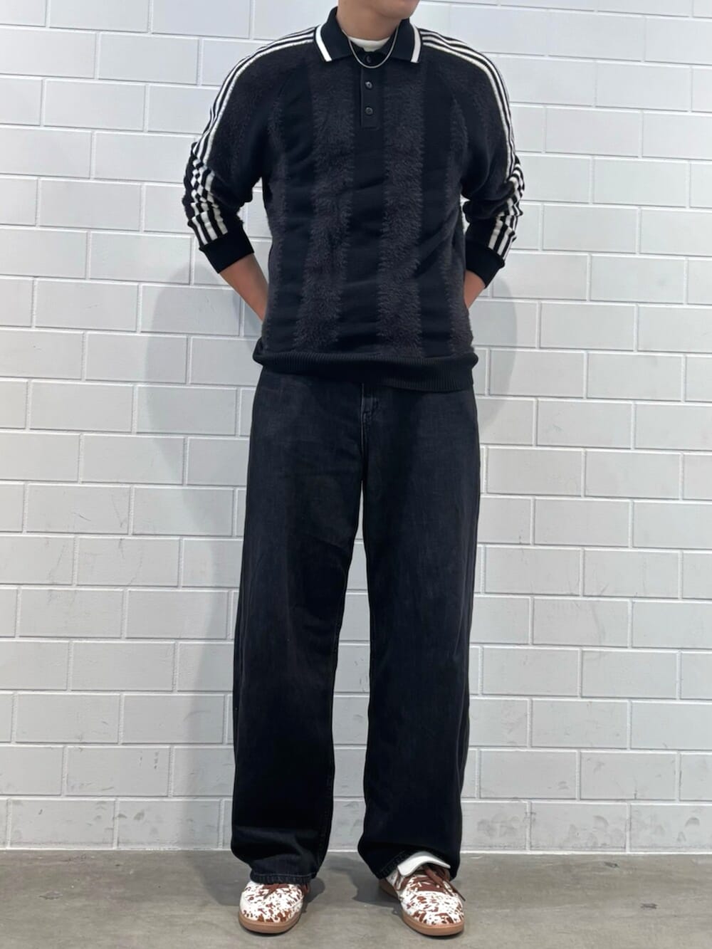 ホワイト系のスニーカー、ブラック系のニット/セーターを着用したメンズの秋コーディネートの2枚目の写真