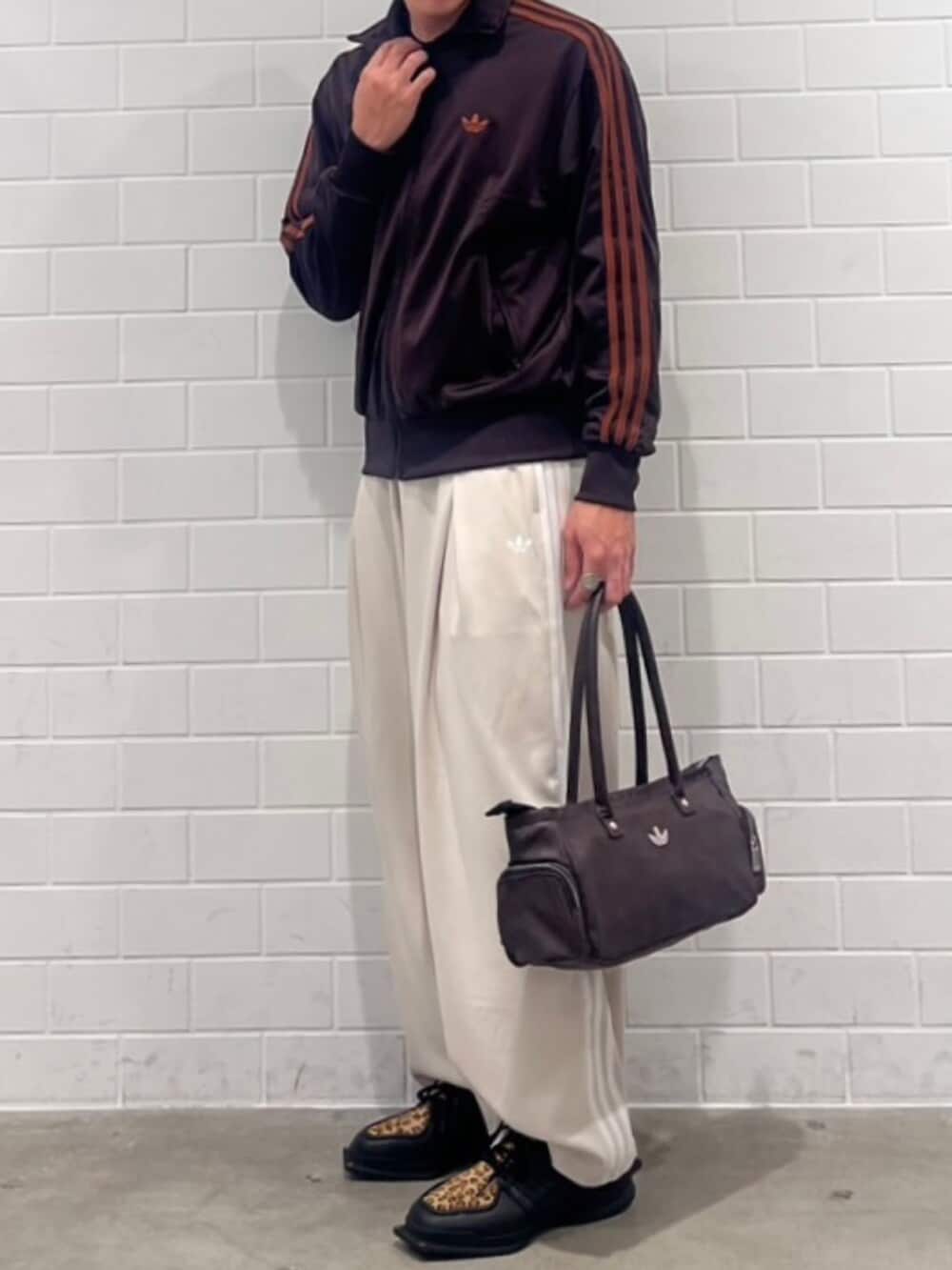 ベージュ系のスウェットパンツ、ブラウン系のジャージ、ブラック系のシューズを着用したメンズの秋コーディネートの2枚目の写真