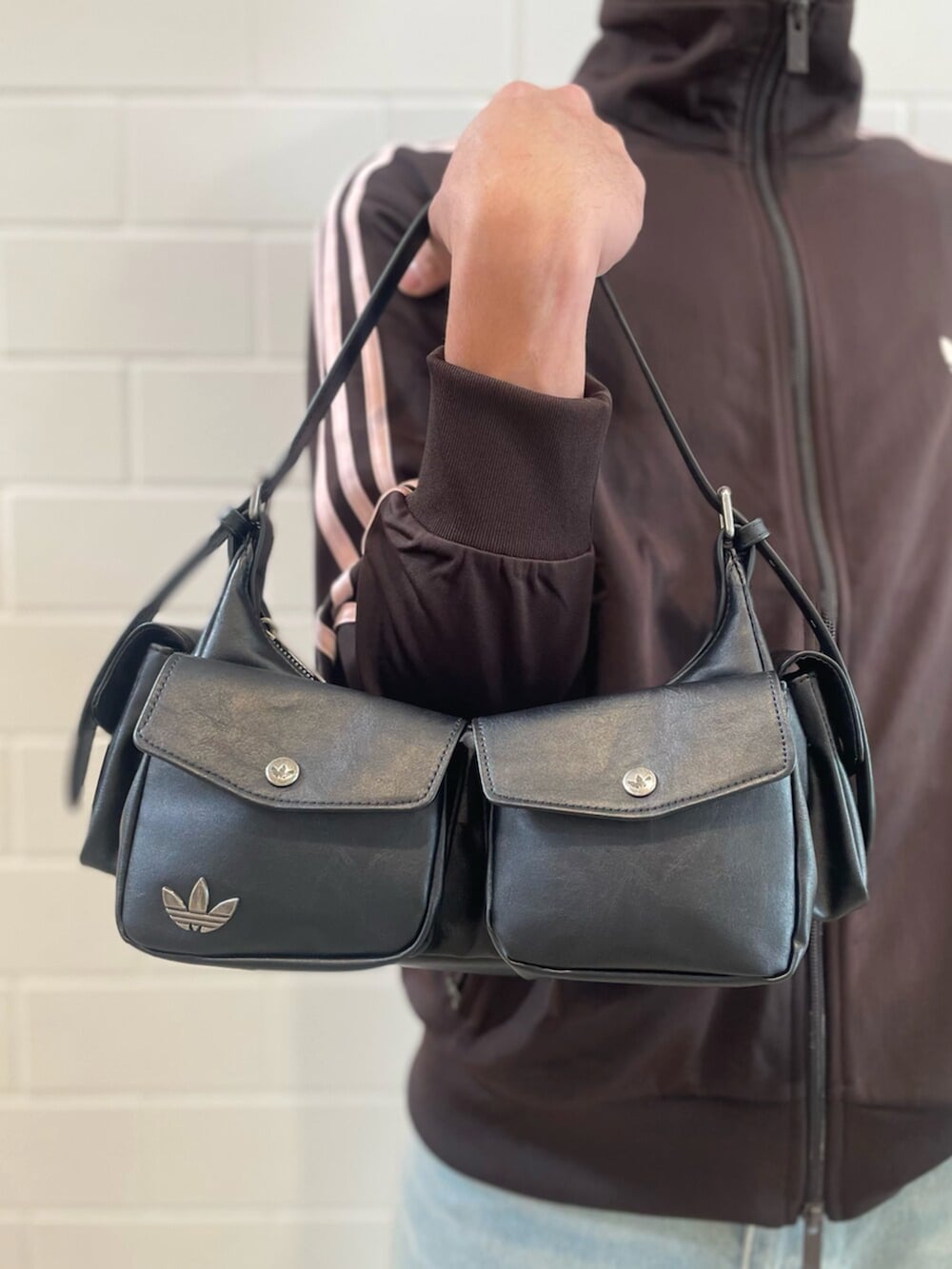 ブラウン系のジャージ、ブルー系のデニムパンツ、ブラック系のショルダーバッグを着用したメンズの春コーディネートの4枚目の写真