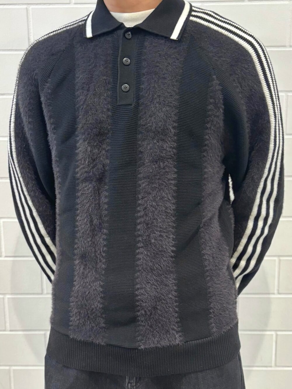 ホワイト系のスニーカー、ブラック系のニット/セーターを着用したメンズの秋コーディネートの3枚目の写真