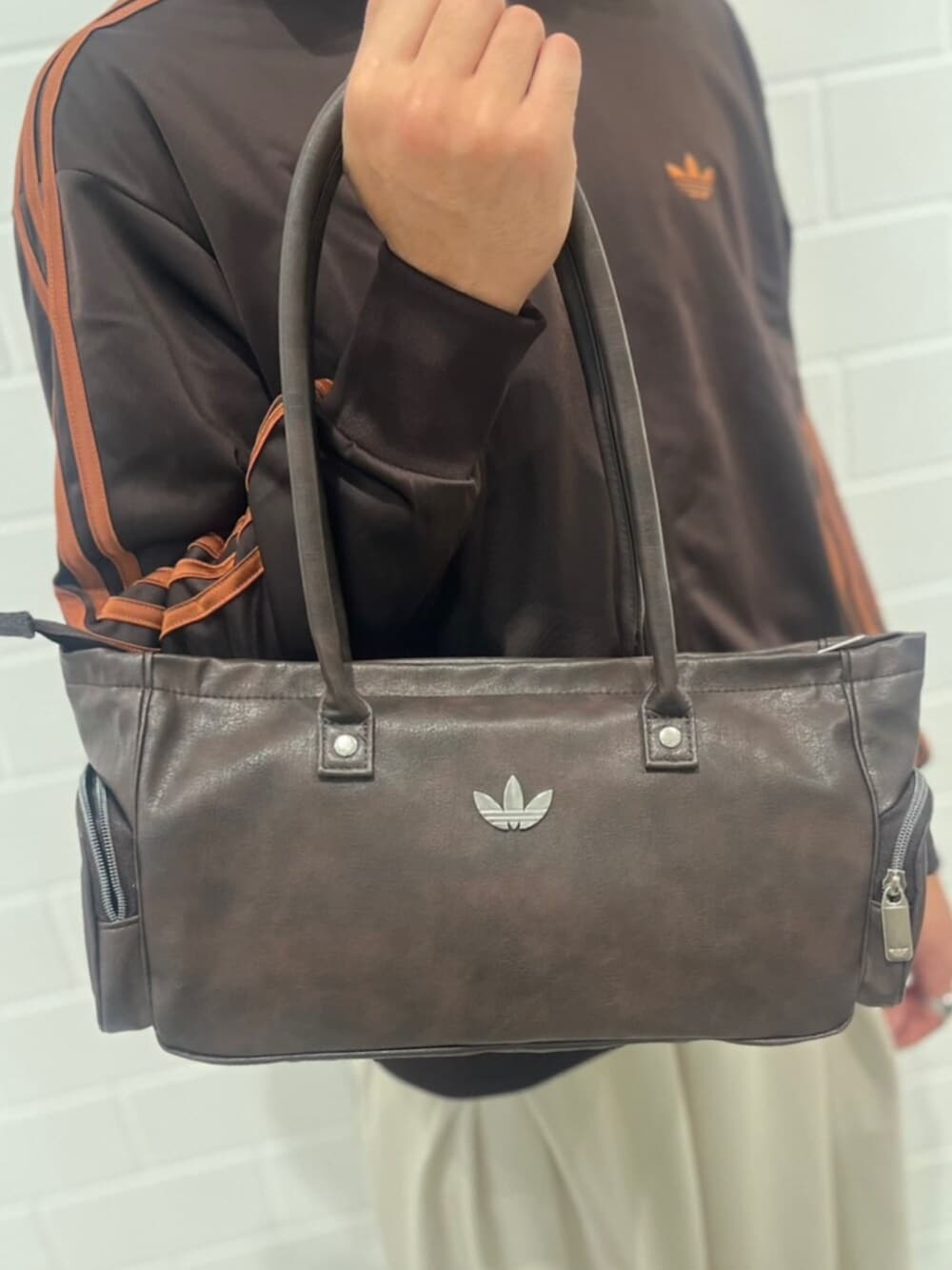ベージュ系のスウェットパンツ、ブラウン系のジャージ、ブラック系のシューズを着用したメンズの秋コーディネートの4枚目の写真