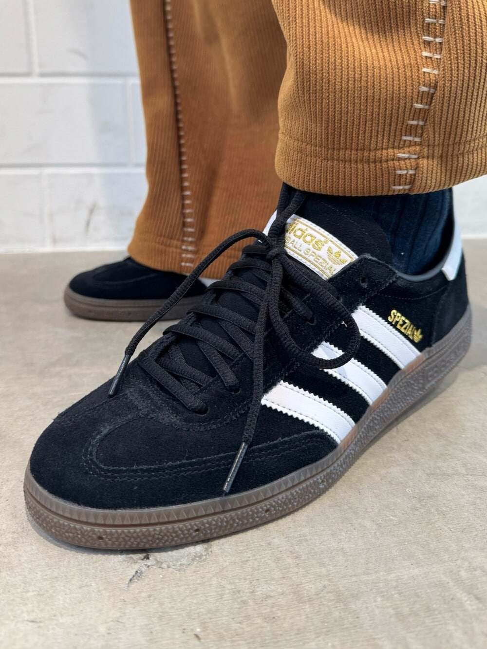 ブラウン系のその他パンツ、ブラック系のトップス、ブラック系のスニーカーを着用したメンズの冬コーディネートの6枚目の写真