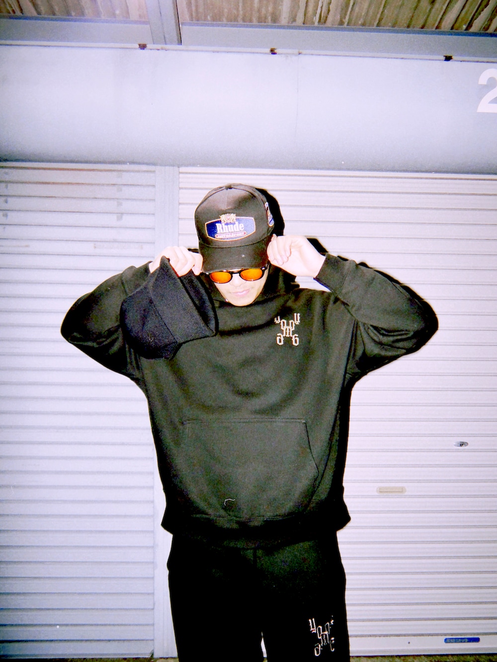 ブラック系のスウェットパンツ、ブラック系のパーカー、ブラック系のキャップを着用したメンズの冬コーディネートの4枚目の写真