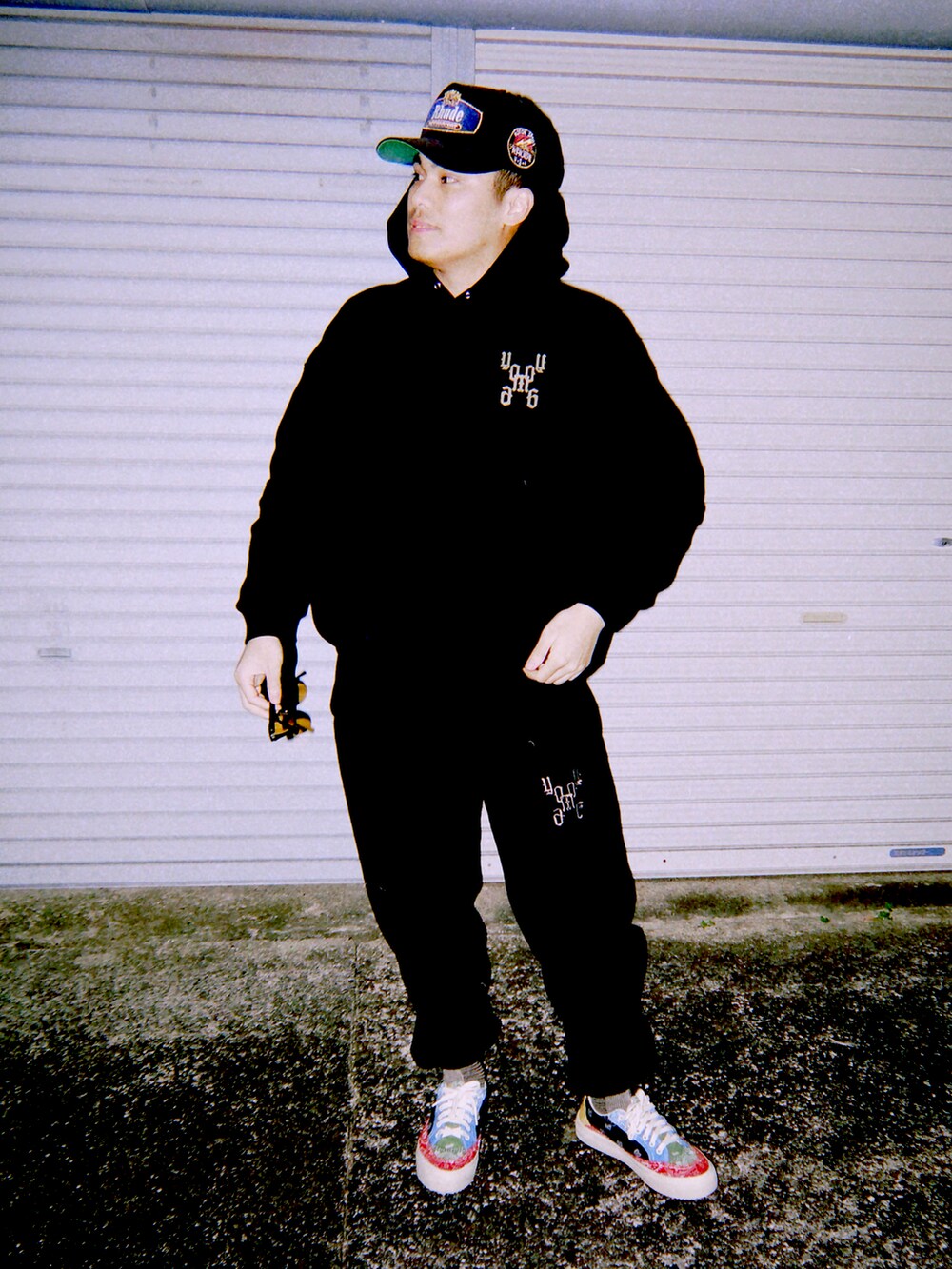 ブラック系のスウェットパンツ、ブラック系のパーカー、ブラック系のキャップを着用したメンズの冬コーディネートの2枚目の写真