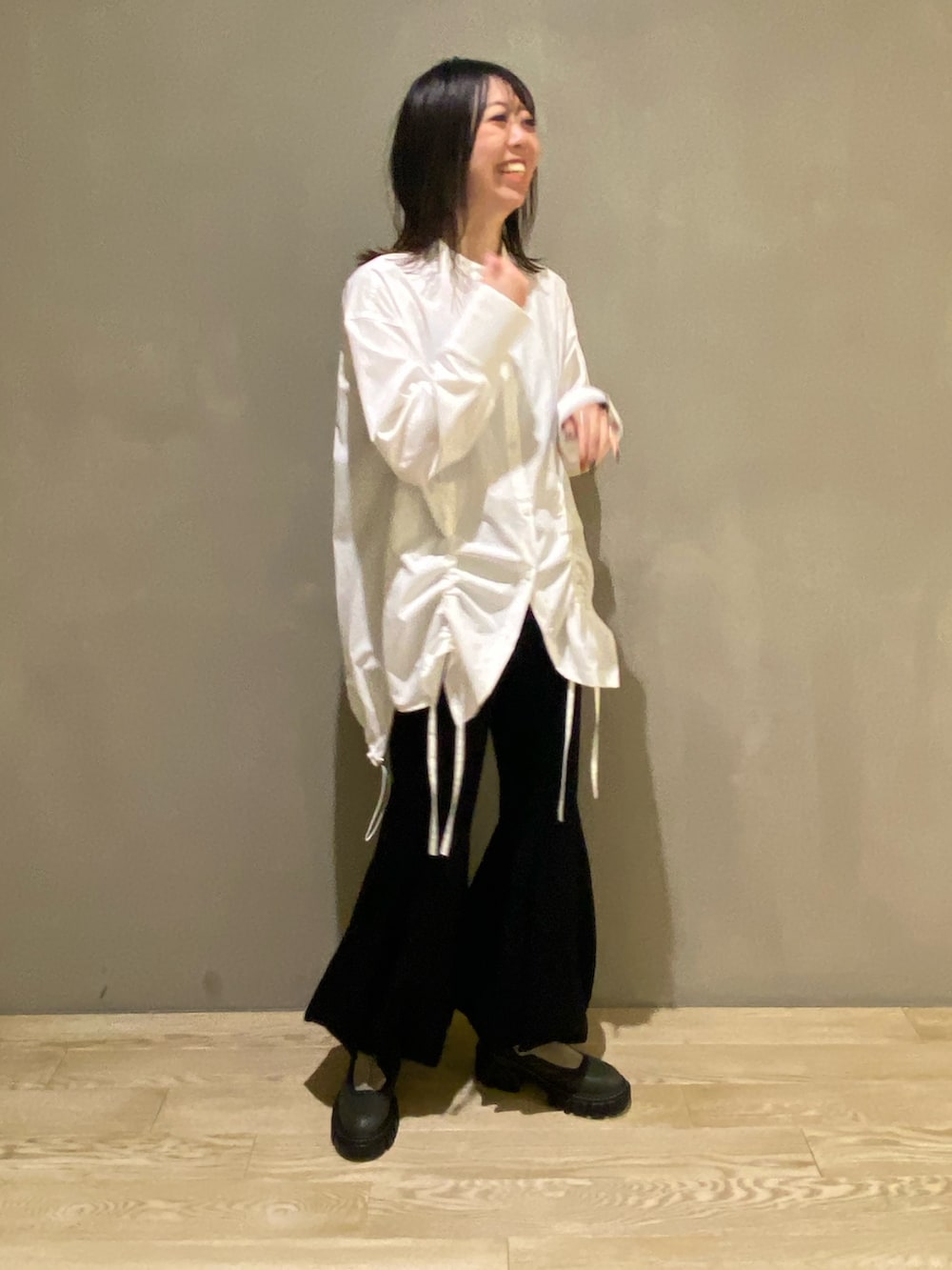 グリーン系のブルゾン、ホワイト系のシャツ/ブラウス、ブラック系のその他パンツを着用したレディースの秋コーディネートの5枚目の写真