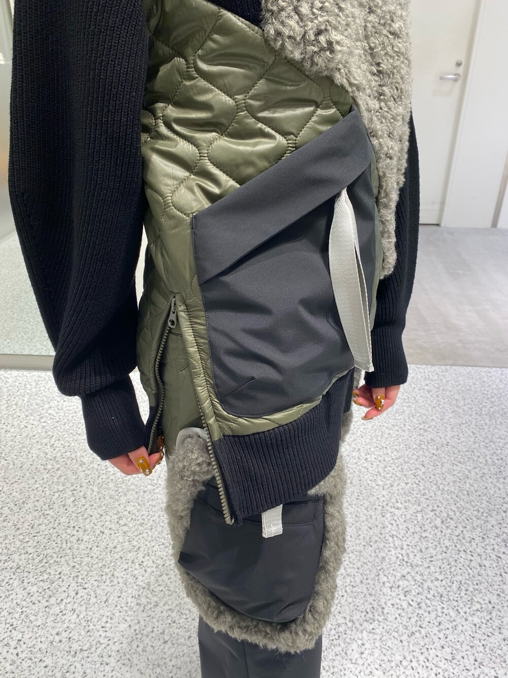 ブラック系のニット/セーター、ブラック系のスカート、レッド系のハンドバッグを着用したレディースの秋コーディネートの6枚目の写真