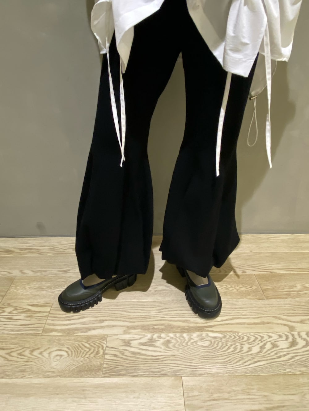 グリーン系のブルゾン、ホワイト系のシャツ/ブラウス、ブラック系のその他パンツを着用したレディースの秋コーディネートの8枚目の写真