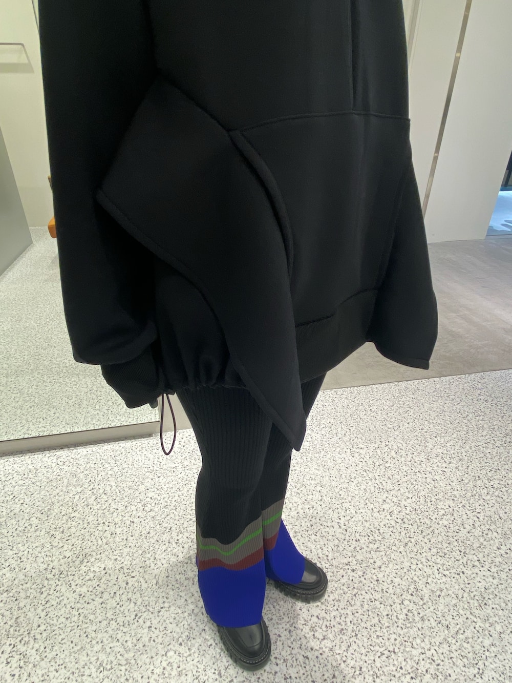 ブラック系のパーカー、ブラック系のその他パンツ、ブラック系のブーツを着用したレディースの秋コーディネートの5枚目の写真