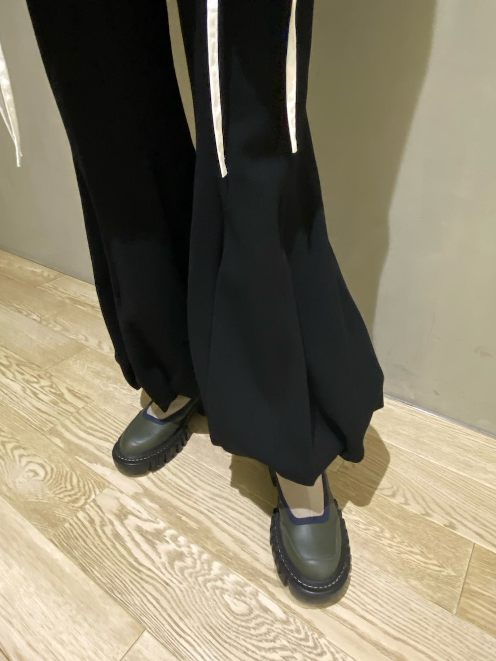 グリーン系のブルゾン、ホワイト系のシャツ/ブラウス、ブラック系のその他パンツを着用したレディースの秋コーディネートの9枚目の写真