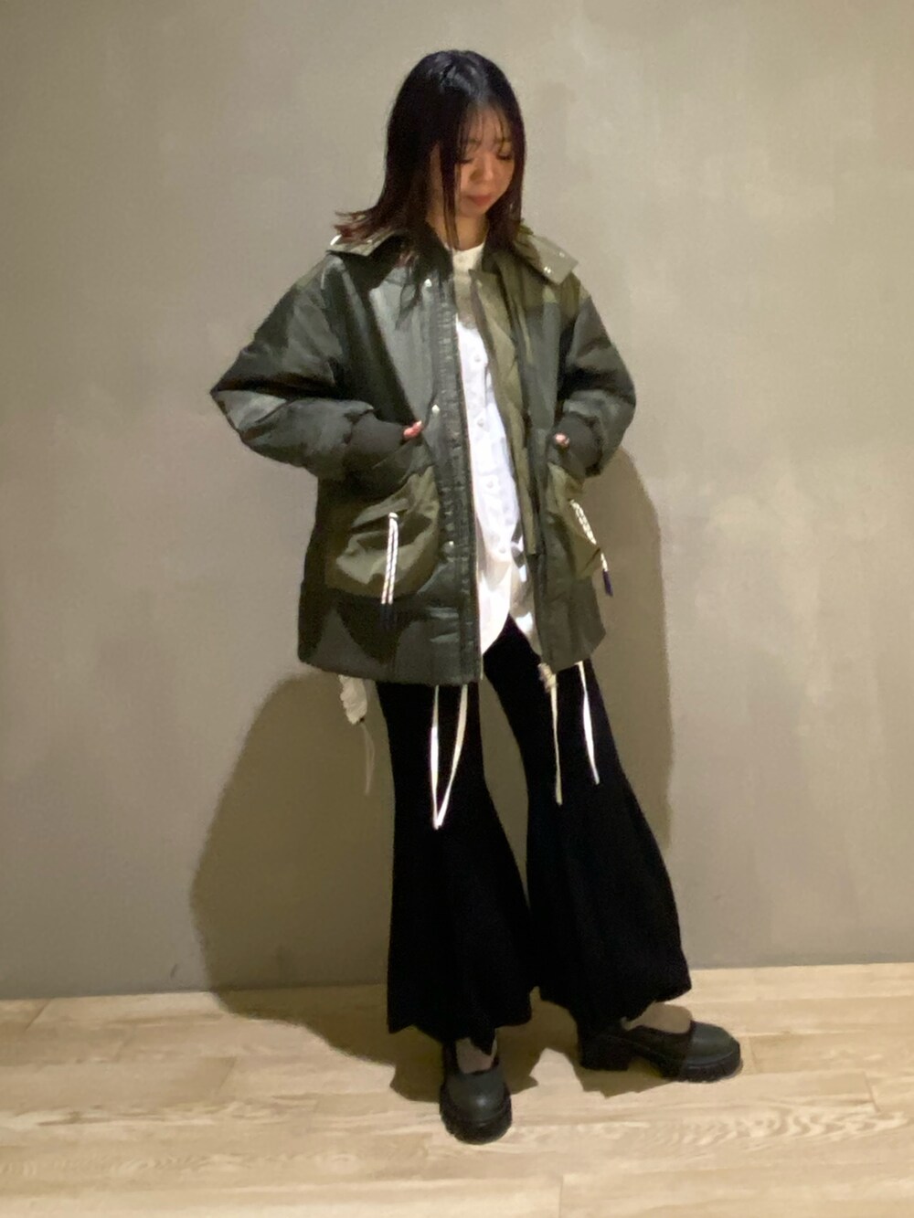 グリーン系のブルゾン、ホワイト系のシャツ/ブラウス、ブラック系のその他パンツを着用したレディースの秋コーディネートの2枚目の写真