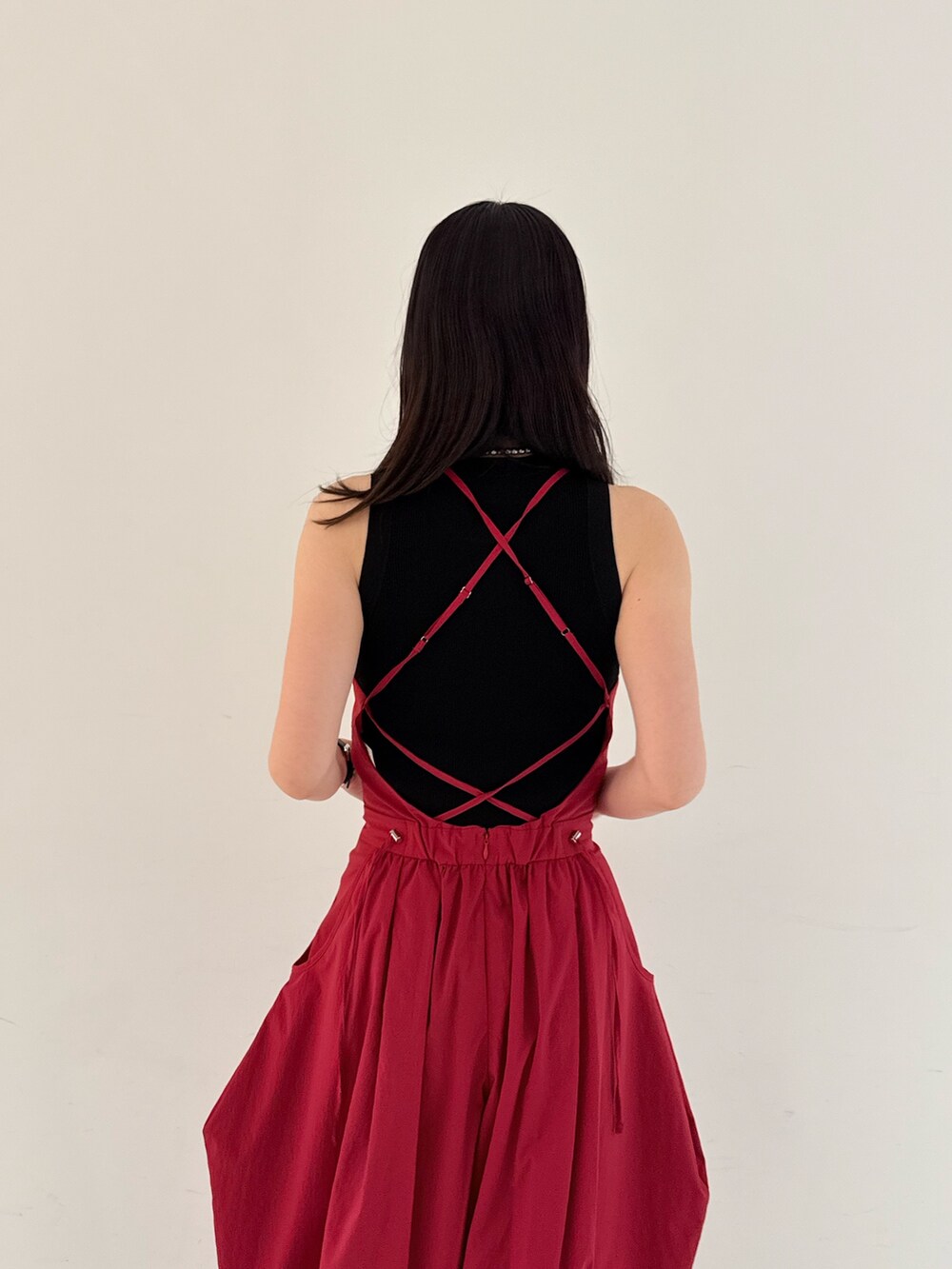 レッド系のつなぎ/オールインワン、ブラック系のタンクトップ、シルバー系のサンダルを着用したレディースの夏コーディネートの6枚目の写真