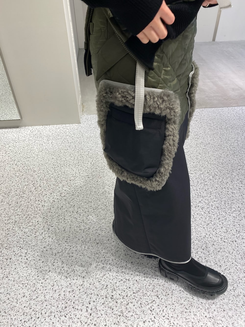 ブラック系のニット/セーター、ブラック系のスカート、レッド系のハンドバッグを着用したレディースの秋コーディネートの8枚目の写真