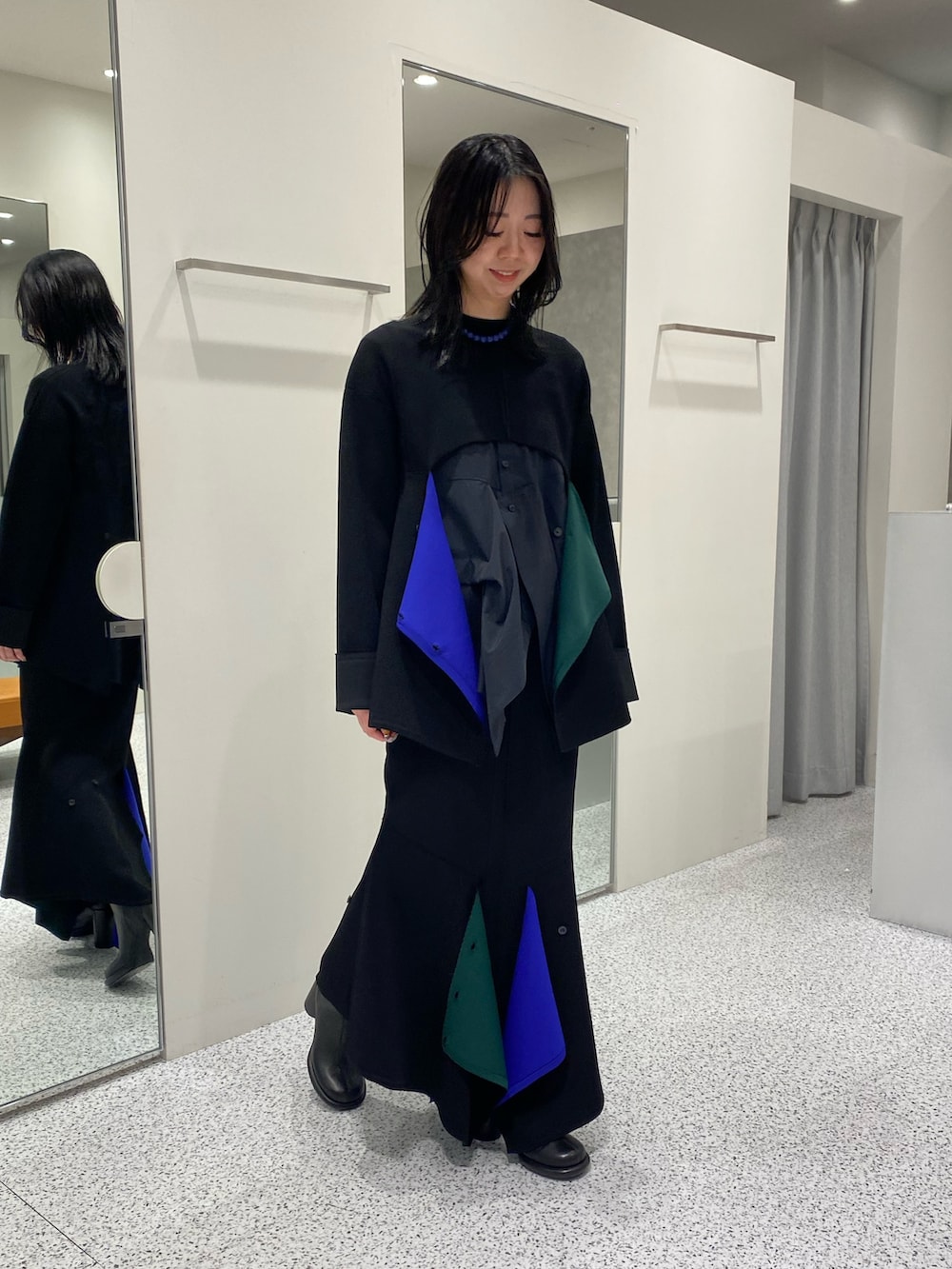 ブラック系のニット/セーター、ブラック系のシャツ/ブラウス、ブラック系のスカートを着用したレディースの冬コーディネートの2枚目の写真