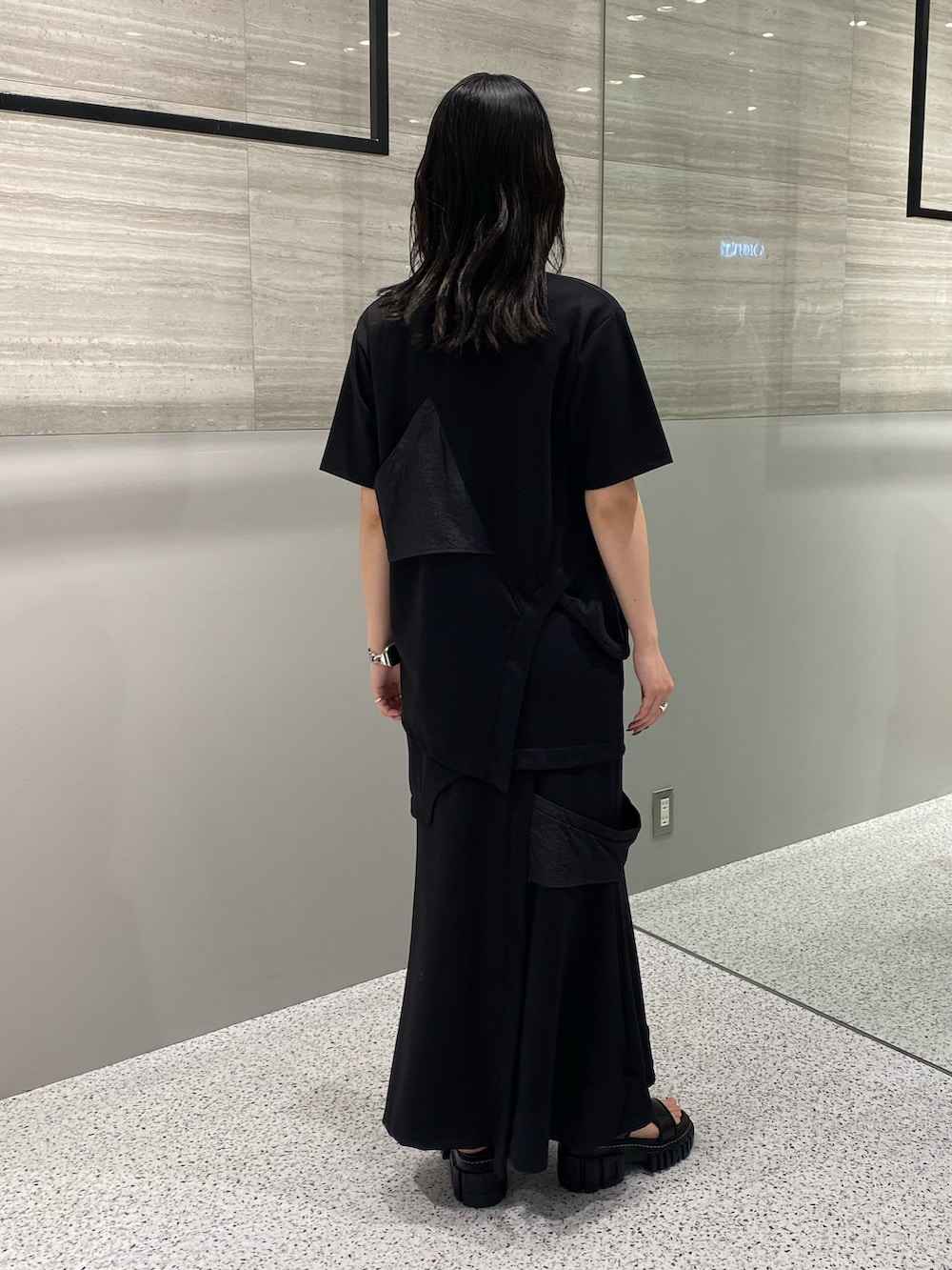 ブラック系のスカート、ブラック系のサンダル、ブラック系のTシャツ/カットソーを着用したレディースの春コーディネートの5枚目の写真