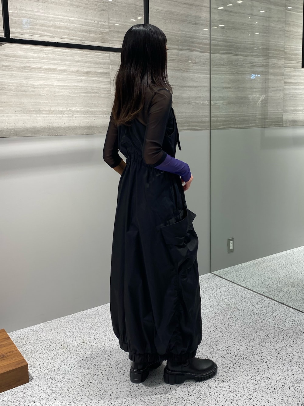 ブラック系のワンピース、ブラック系のTシャツ/カットソー、ブラック系のブーツを着用したレディースの秋コーディネートの3枚目の写真