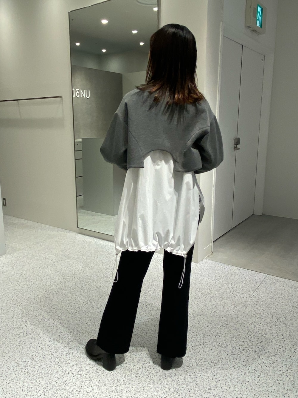 グレー系のノーカラージャケット、ホワイト系のシャツ/ブラウス、ブラック系のその他パンツを着用したレディースの冬コーディネートの4枚目の写真