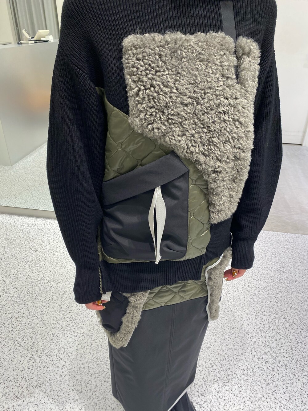 ブラック系のニット/セーター、ブラック系のスカート、レッド系のハンドバッグを着用したレディースの秋コーディネートの5枚目の写真