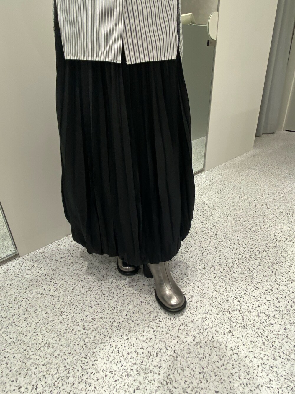 ブラック系のシャツ/ブラウス、ブラック系のスカート、シルバー系のブーツを着用したレディースの冬コーディネートの8枚目の写真