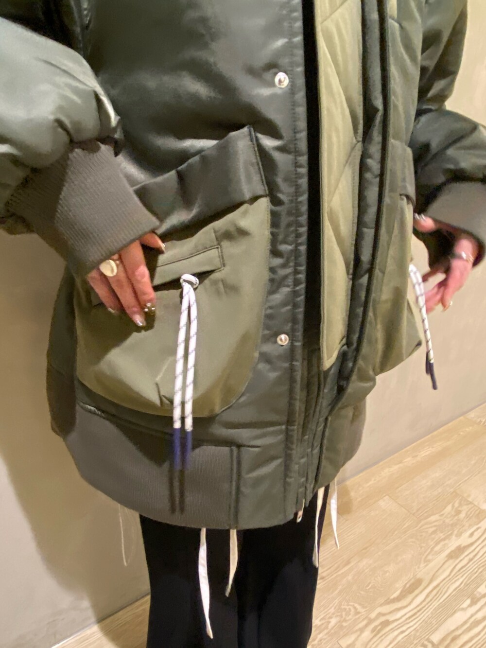 グリーン系のブルゾン、ホワイト系のシャツ/ブラウス、ブラック系のその他パンツを着用したレディースの秋コーディネートの6枚目の写真