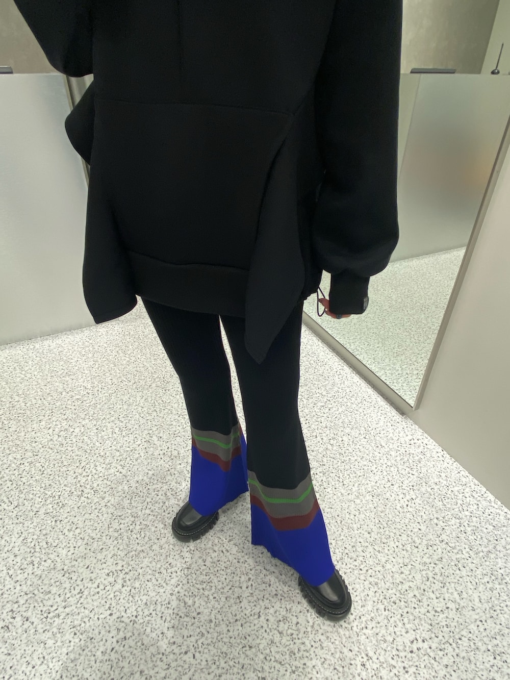 ブラック系のパーカー、ブラック系のその他パンツ、ブラック系のブーツを着用したレディースの秋コーディネートの6枚目の写真