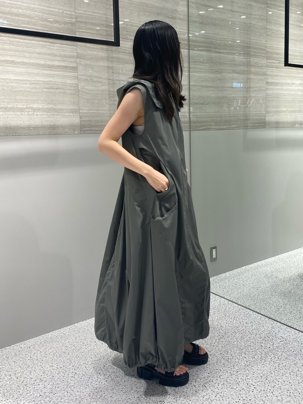 グレー系のワンピース、ブラック系のサンダルを着用したレディースの秋コーディネートの4枚目の写真