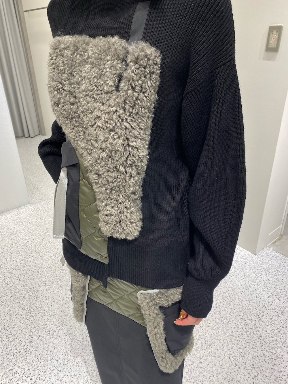 ブラック系のニット/セーター、ブラック系のスカート、レッド系のハンドバッグを着用したレディースの秋コーディネートの7枚目の写真