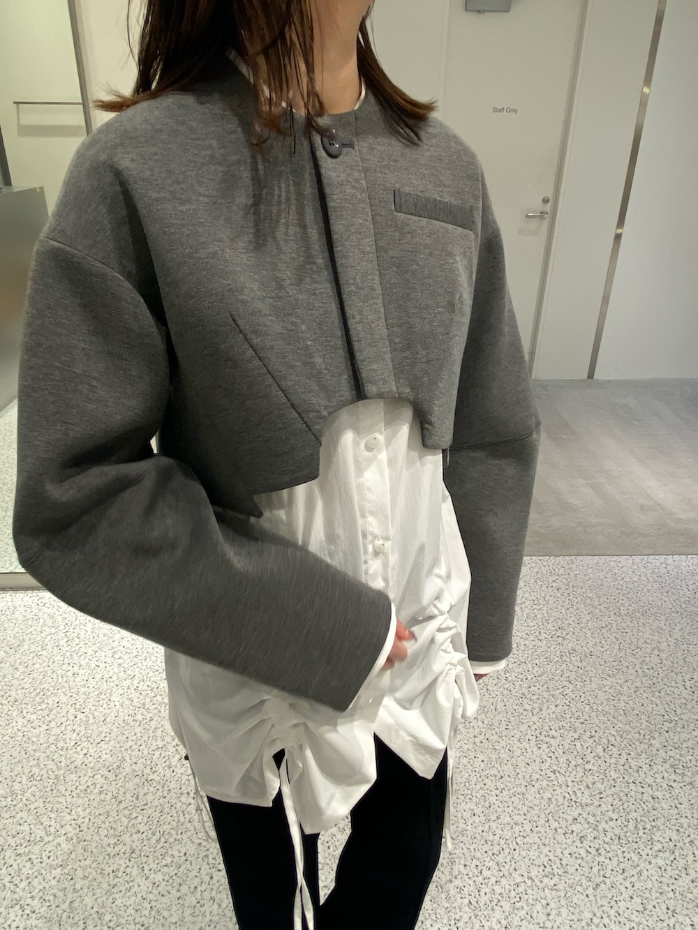 グレー系のノーカラージャケット、ホワイト系のシャツ/ブラウス、ブラック系のその他パンツを着用したレディースの冬コーディネートの6枚目の写真