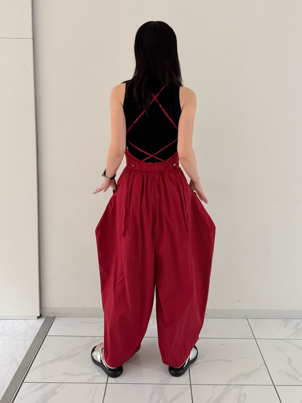 レッド系のつなぎ/オールインワン、ブラック系のタンクトップ、シルバー系のサンダルを着用したレディースの夏コーディネートの4枚目の写真