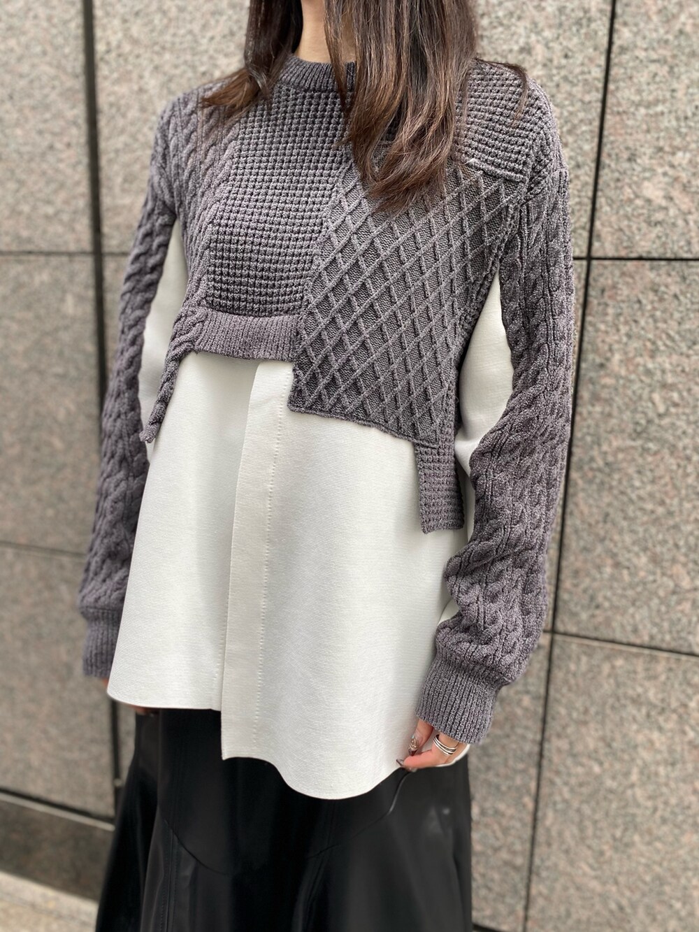 グレー系のニット/セーター、ブラック系のスカート、ブラック系のブーツを着用したレディースの秋コーディネートの6枚目の写真