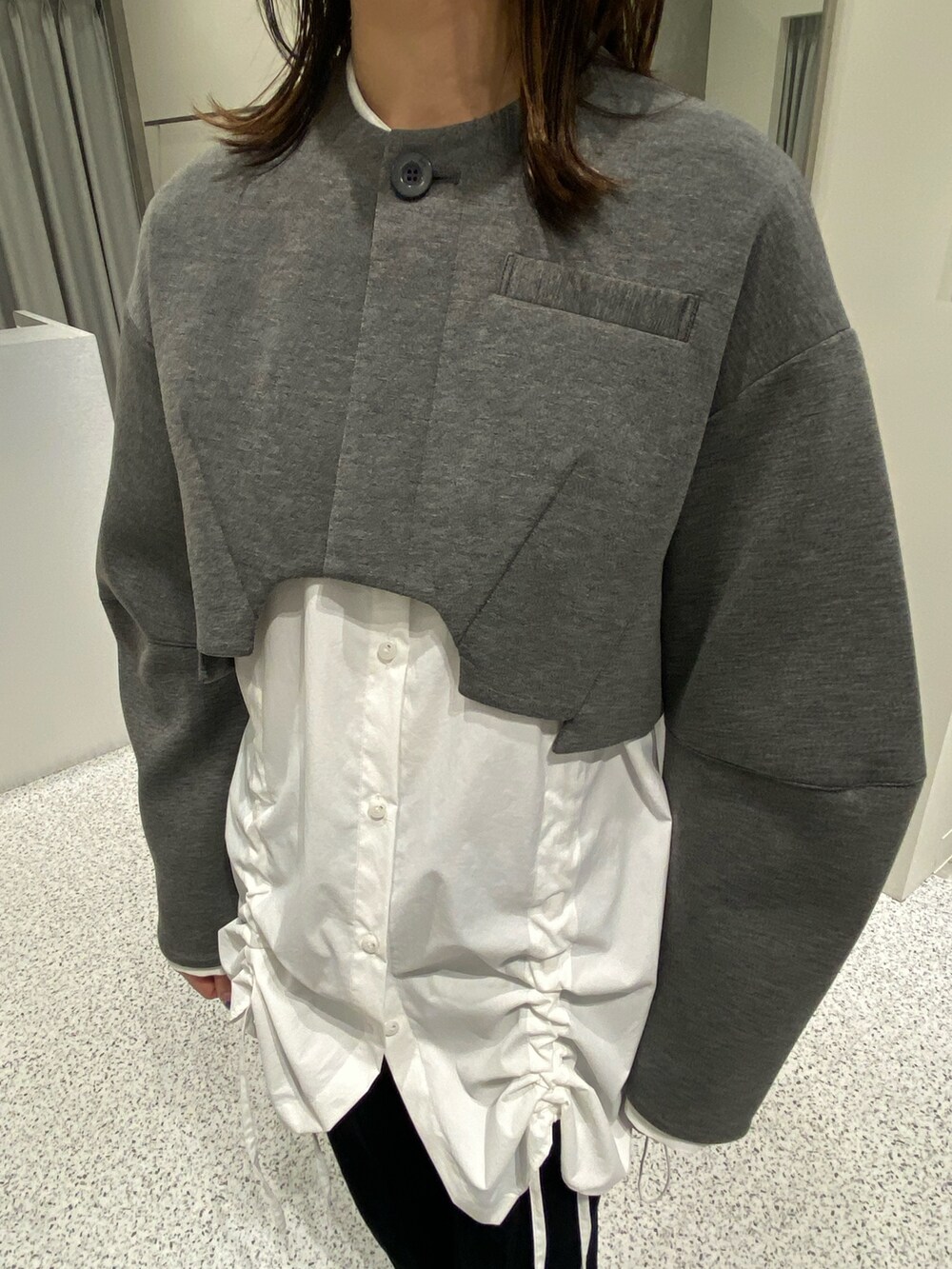 グレー系のノーカラージャケット、ホワイト系のシャツ/ブラウス、ブラック系のその他パンツを着用したレディースの冬コーディネートの7枚目の写真