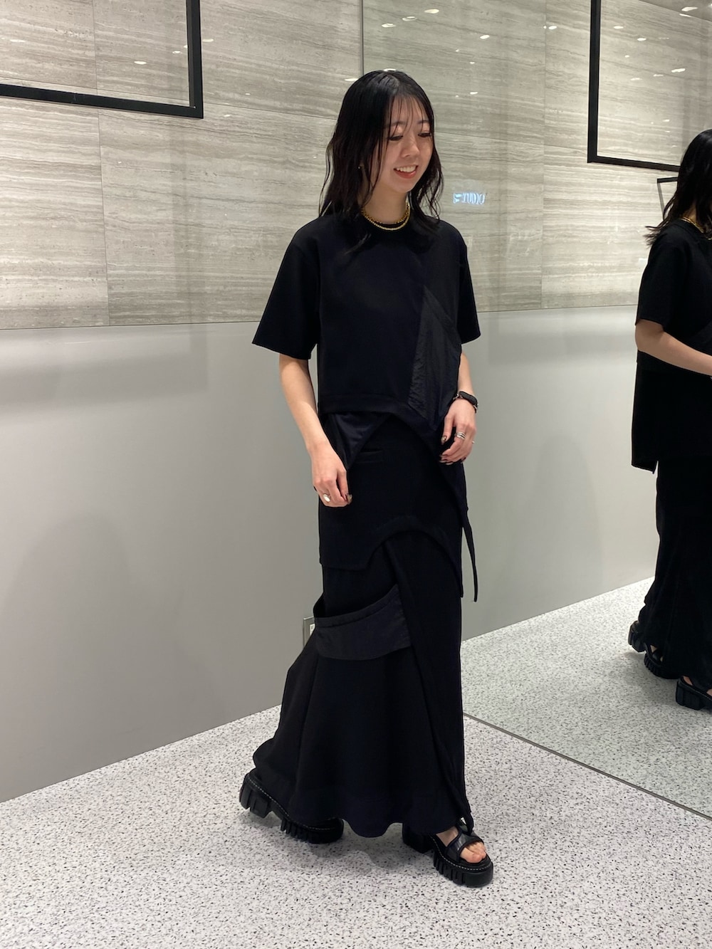 ブラック系のスカート、ブラック系のサンダル、ブラック系のTシャツ/カットソーを着用したレディースの春コーディネートの4枚目の写真