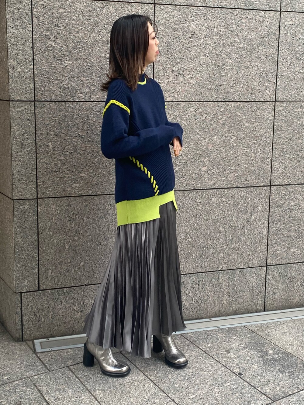 ブルー系のニット/セーター、グレー系のスカート、シルバー系のブーツを着用したレディースの冬コーディネートの2枚目の写真