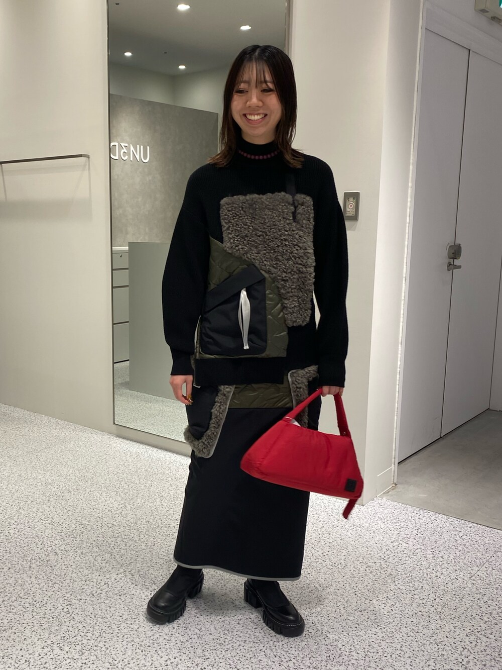 ブラック系のニット/セーター、ブラック系のスカート、レッド系のハンドバッグを着用したレディースの秋コーディネートの2枚目の写真