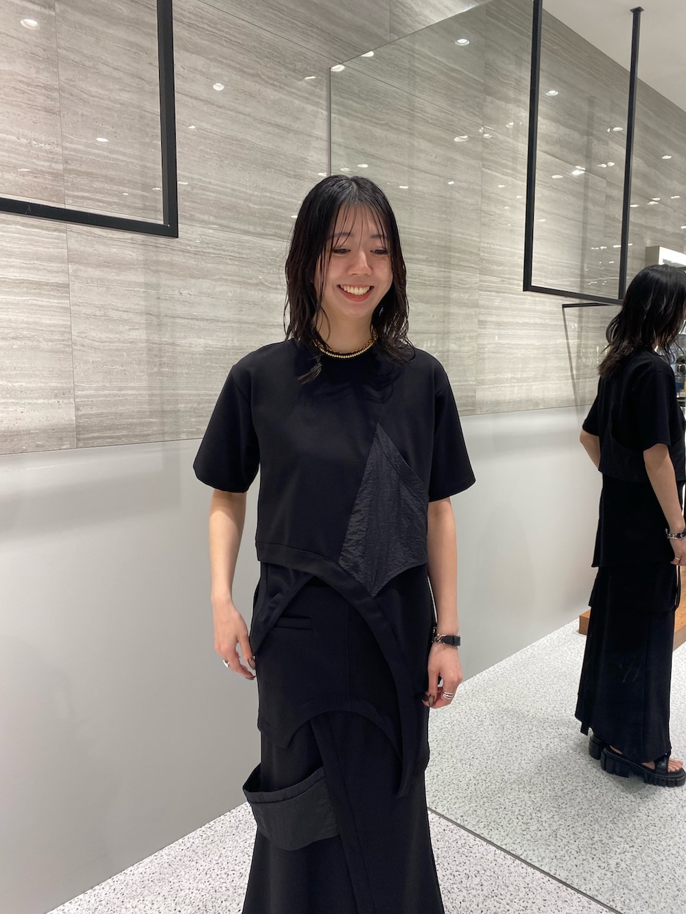 ブラック系のスカート、ブラック系のサンダル、ブラック系のTシャツ/カットソーを着用したレディースの春コーディネートの6枚目の写真