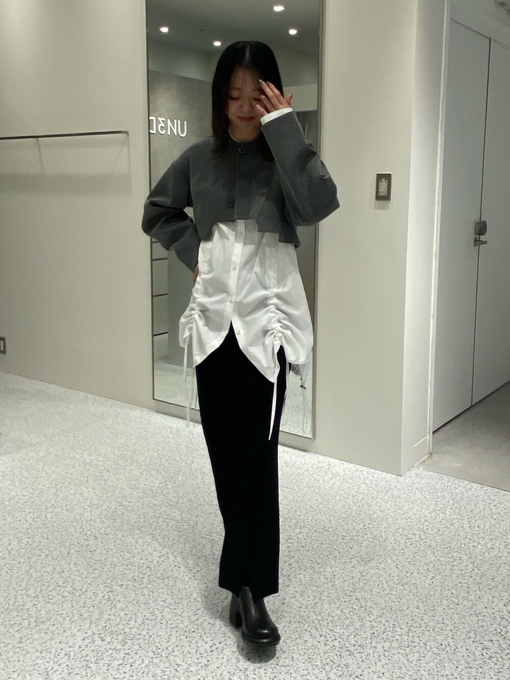 グレー系のノーカラージャケット、ホワイト系のシャツ/ブラウス、ブラック系のその他パンツを着用したレディースの冬コーディネートの2枚目の写真