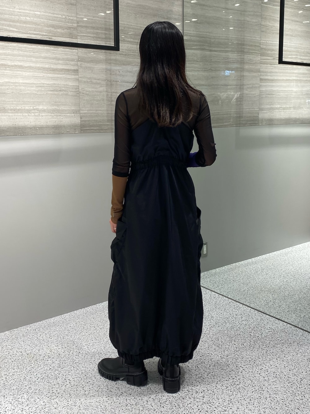 ブラック系のワンピース、ブラック系のTシャツ/カットソー、ブラック系のブーツを着用したレディースの秋コーディネートの4枚目の写真