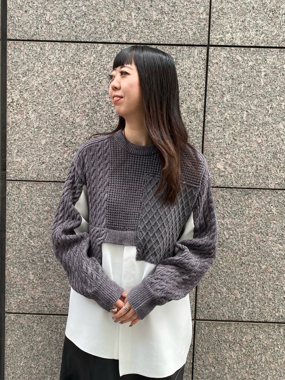 グレー系のニット/セーター、ブラック系のスカート、ブラック系のブーツを着用したレディースの秋コーディネートの5枚目の写真