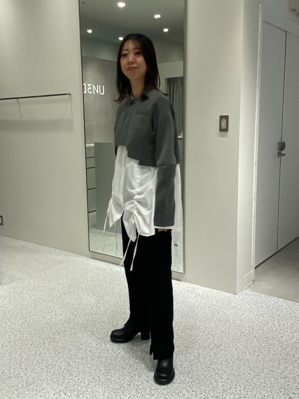 グレー系のノーカラージャケット、ホワイト系のシャツ/ブラウス、ブラック系のその他パンツを着用したレディースの冬コーディネートの3枚目の写真